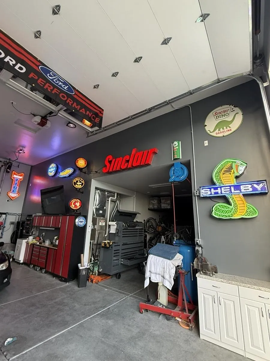 A garage wall of glowing neon signs from Kings Garage, a Crap Kings company